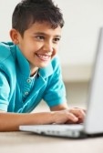 6800615-closeup-portrait-of-a-happy-little-kid-using-a-laptop-on-floor